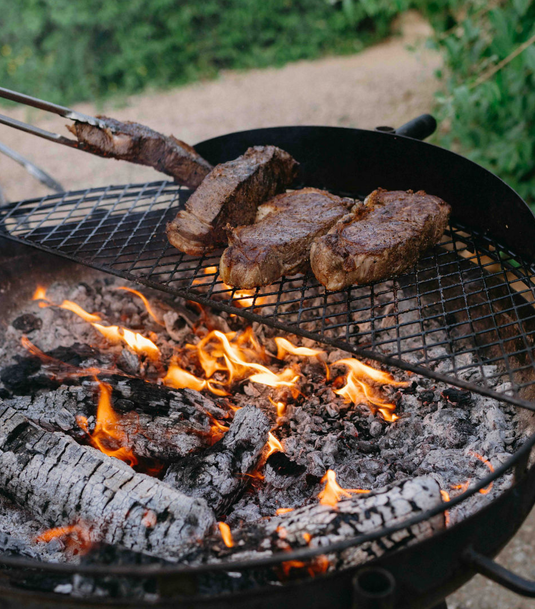 Steaks grilling on open flame