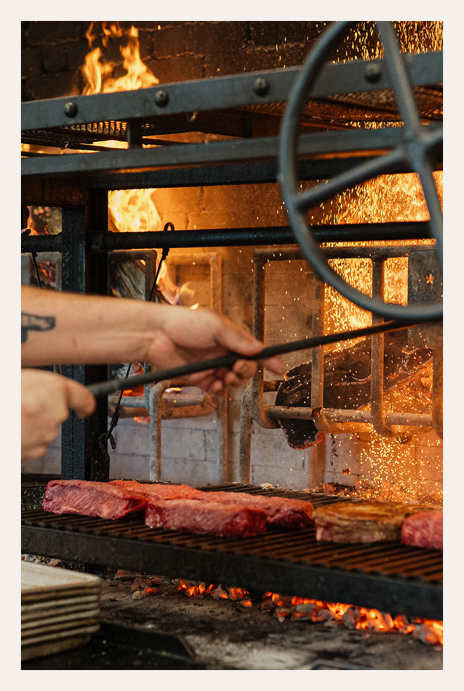 Wood Grill at Vaquera with steaks on it